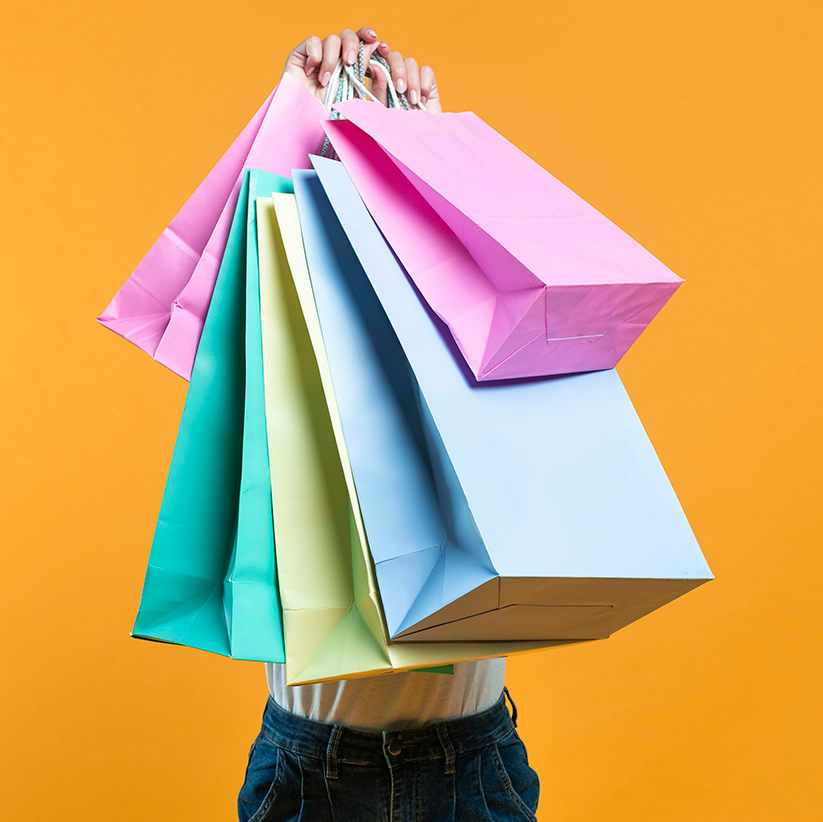 front-view-woman-holding-up-sale-shopping-bags